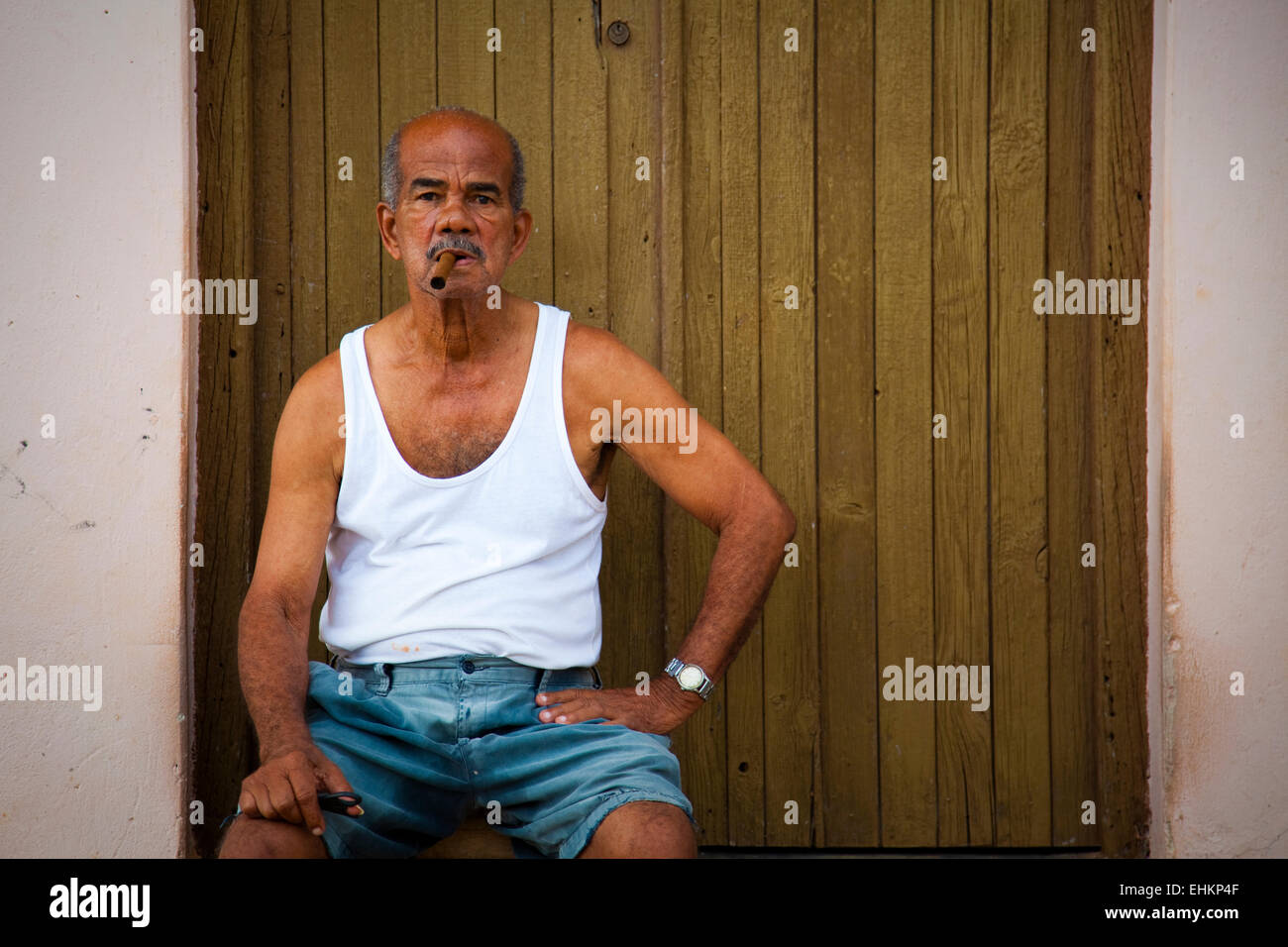 ein-alter-mann-sitzt-in-einem-hauseingang-in-trinidad-kuba-ehkp4f.jpg