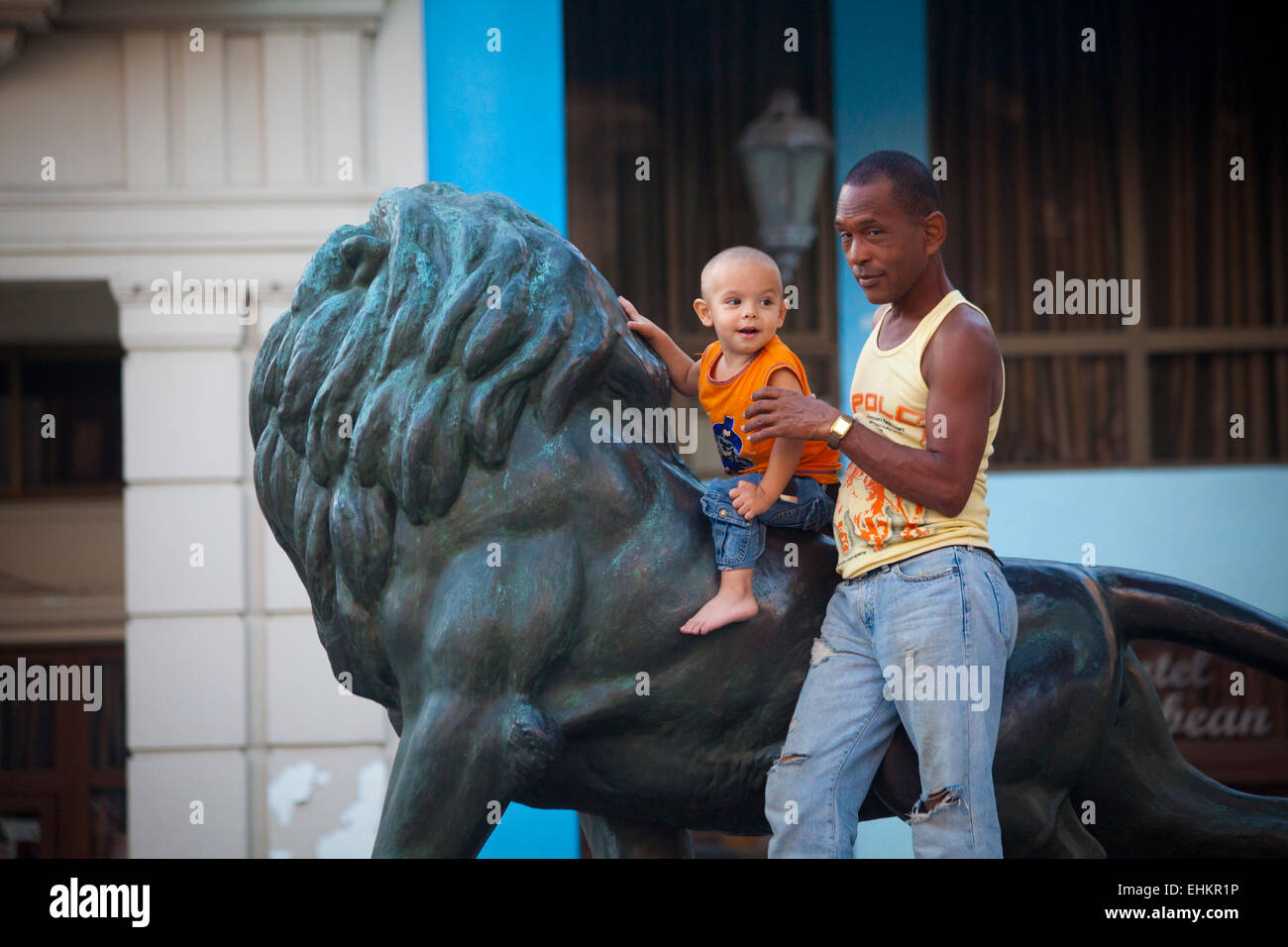 Vater und Sohn spielen auf der Löwenstatue auf dem Prado, Havanna, Kuba Stockfoto