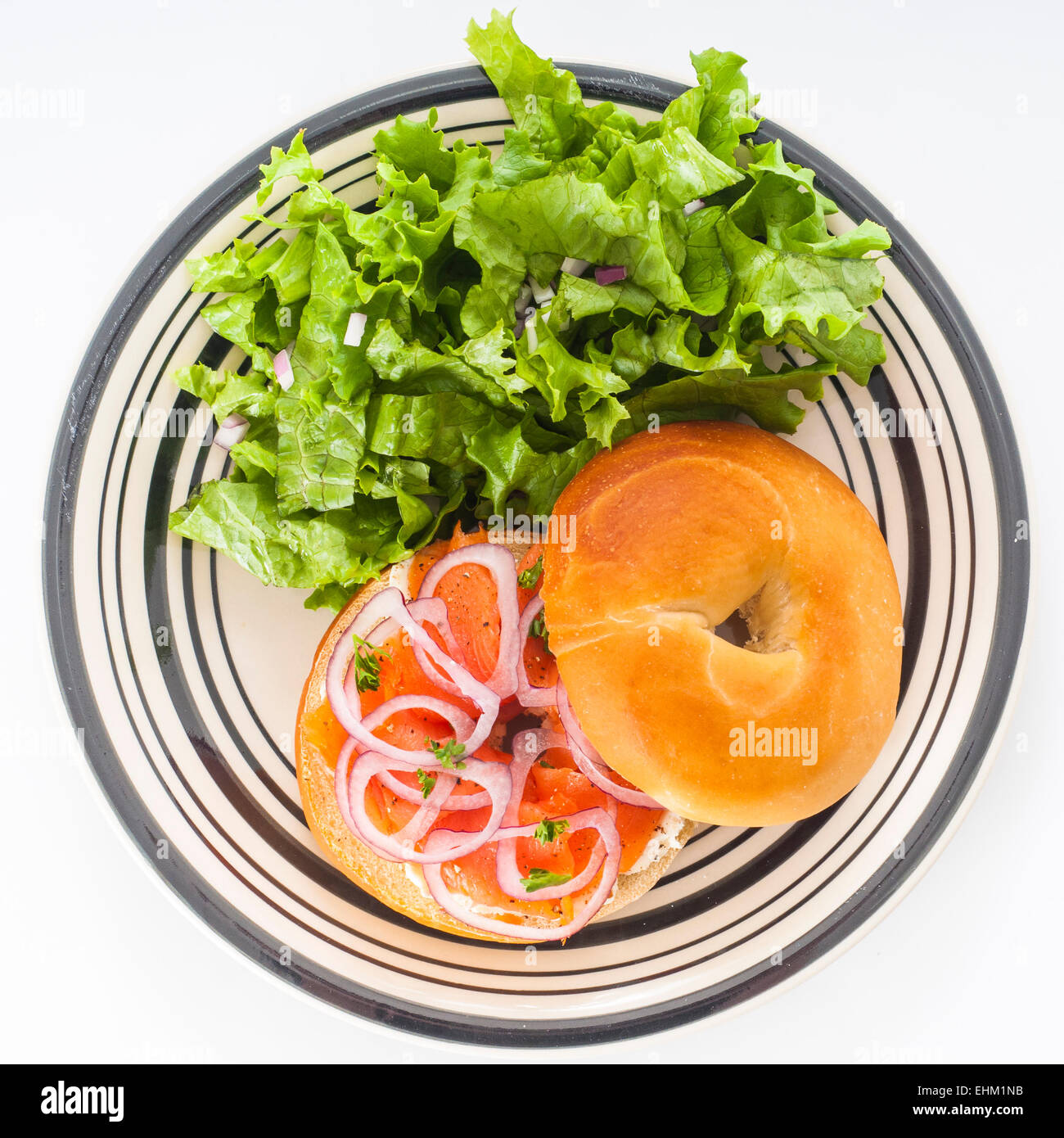 Bagel mit geräucherter Lachs Räucherlachs, Frischkäse und roten Zwiebeln, dazu Salat Salat. Stockfoto