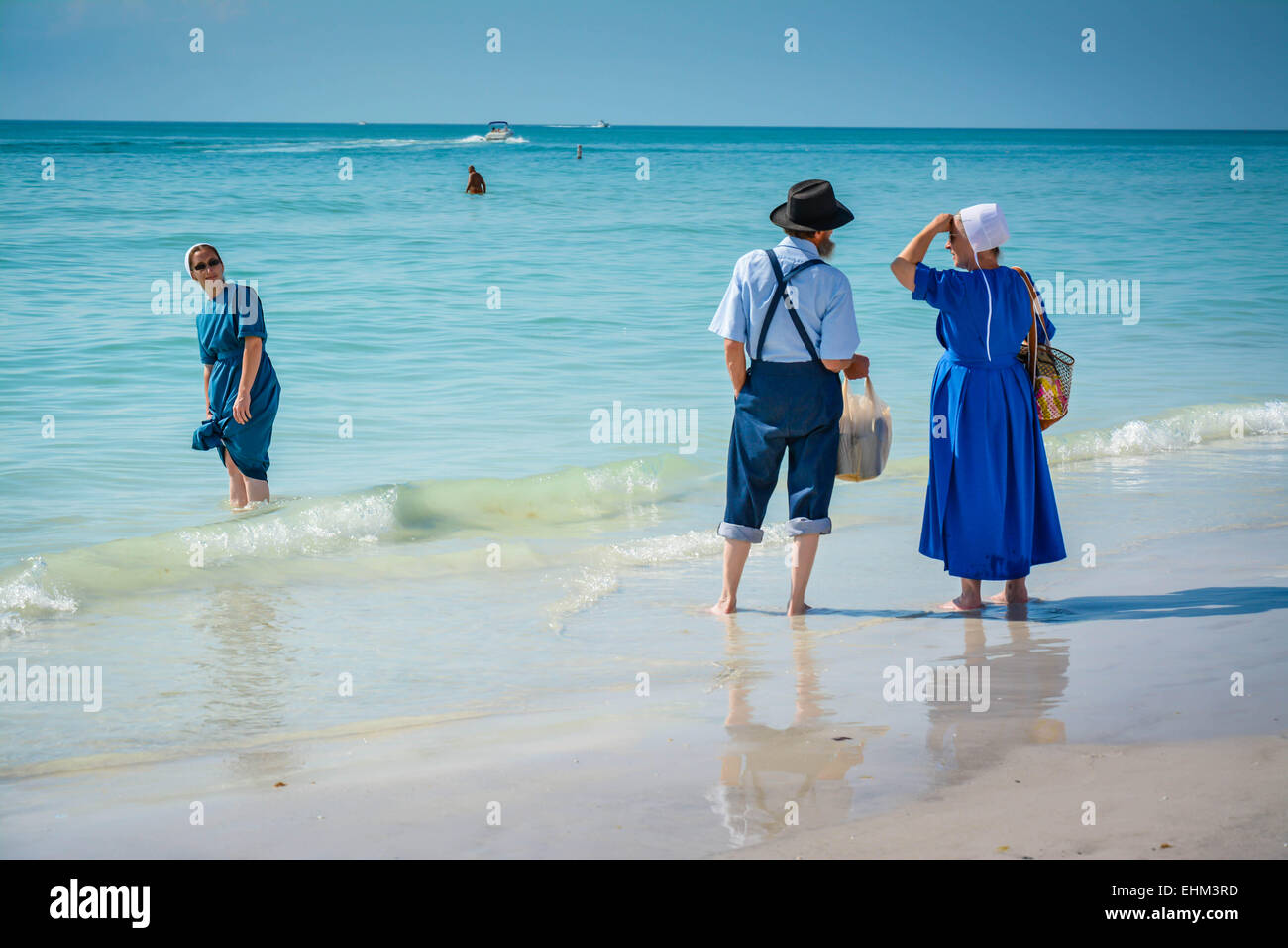 Drei amischen Leute, gekleidet in ihrer traditionellen Weise Paddel in der seichten Brandung am Siesta Key Beach in Sarasota, FL Stockfoto Drei amischen Leute, gekleidet in ihrer traditionellen Weise Paddel in der seichten Brandung am Siesta Key Beach in Sarasota, FL Stockfoto