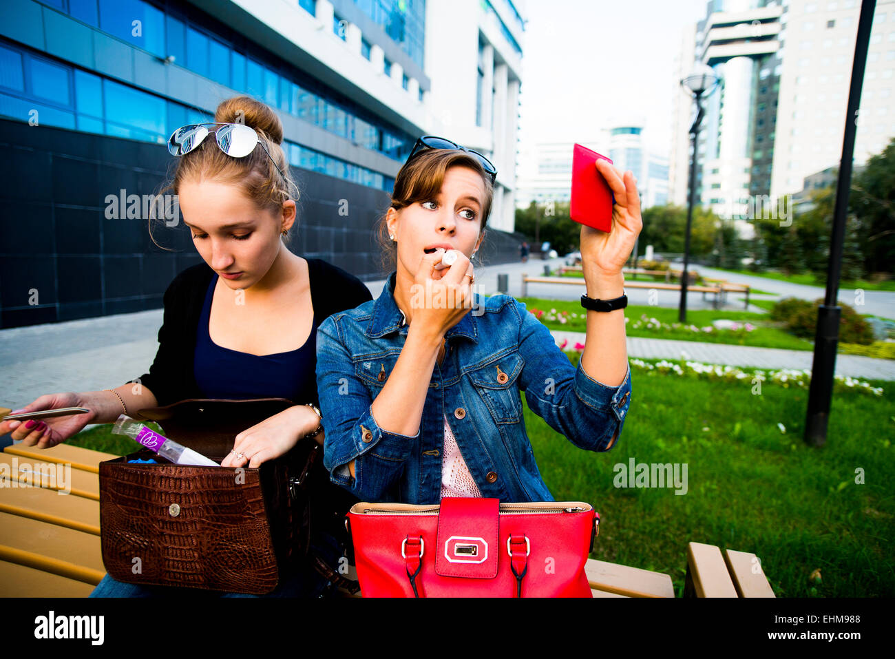 Kaukasische Frau beim Schminken auf Parkbank Stockfoto