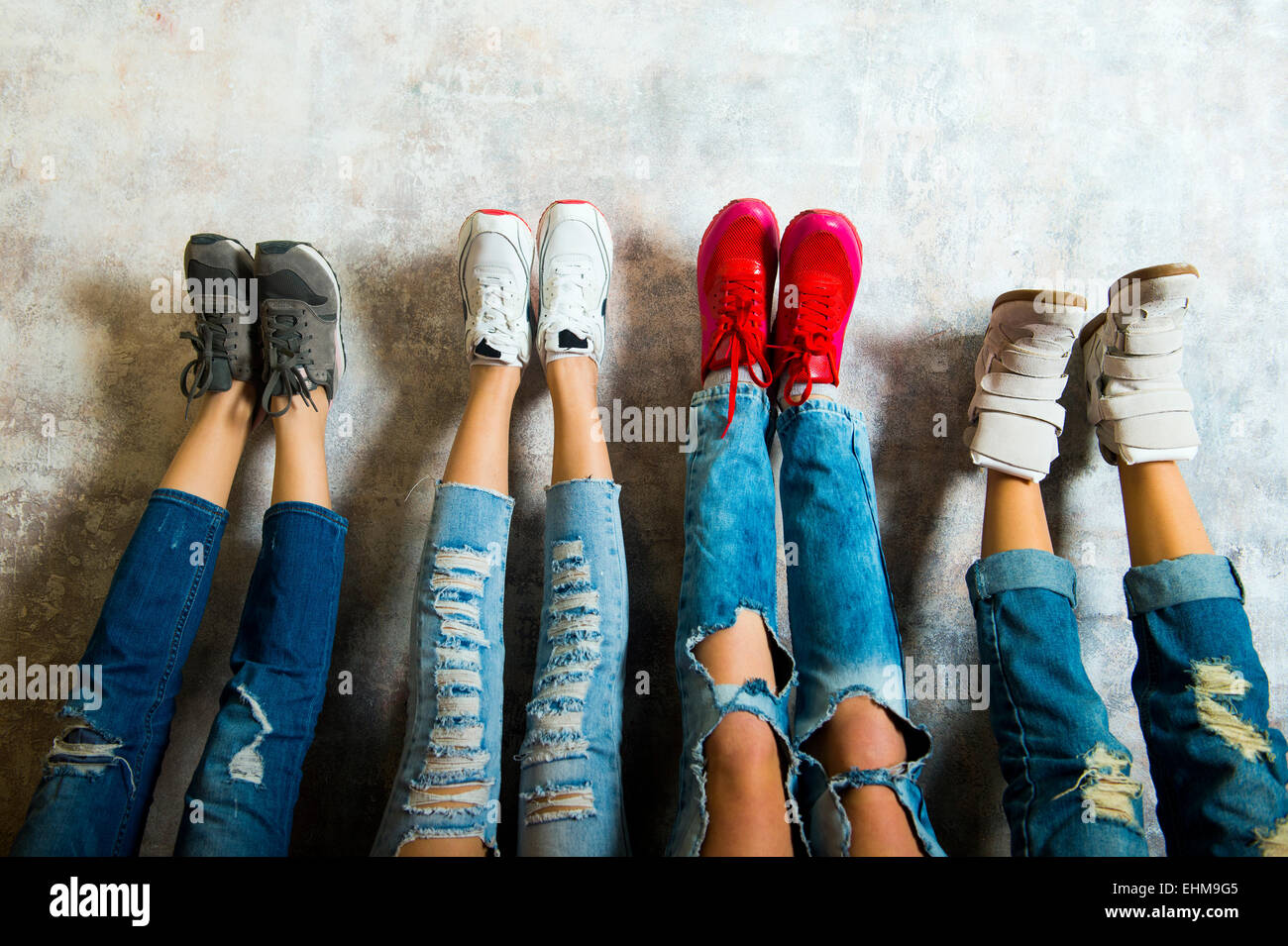 Kaukasischen Frauen bewundern ihre Turnschuhe an Wand Stockfoto