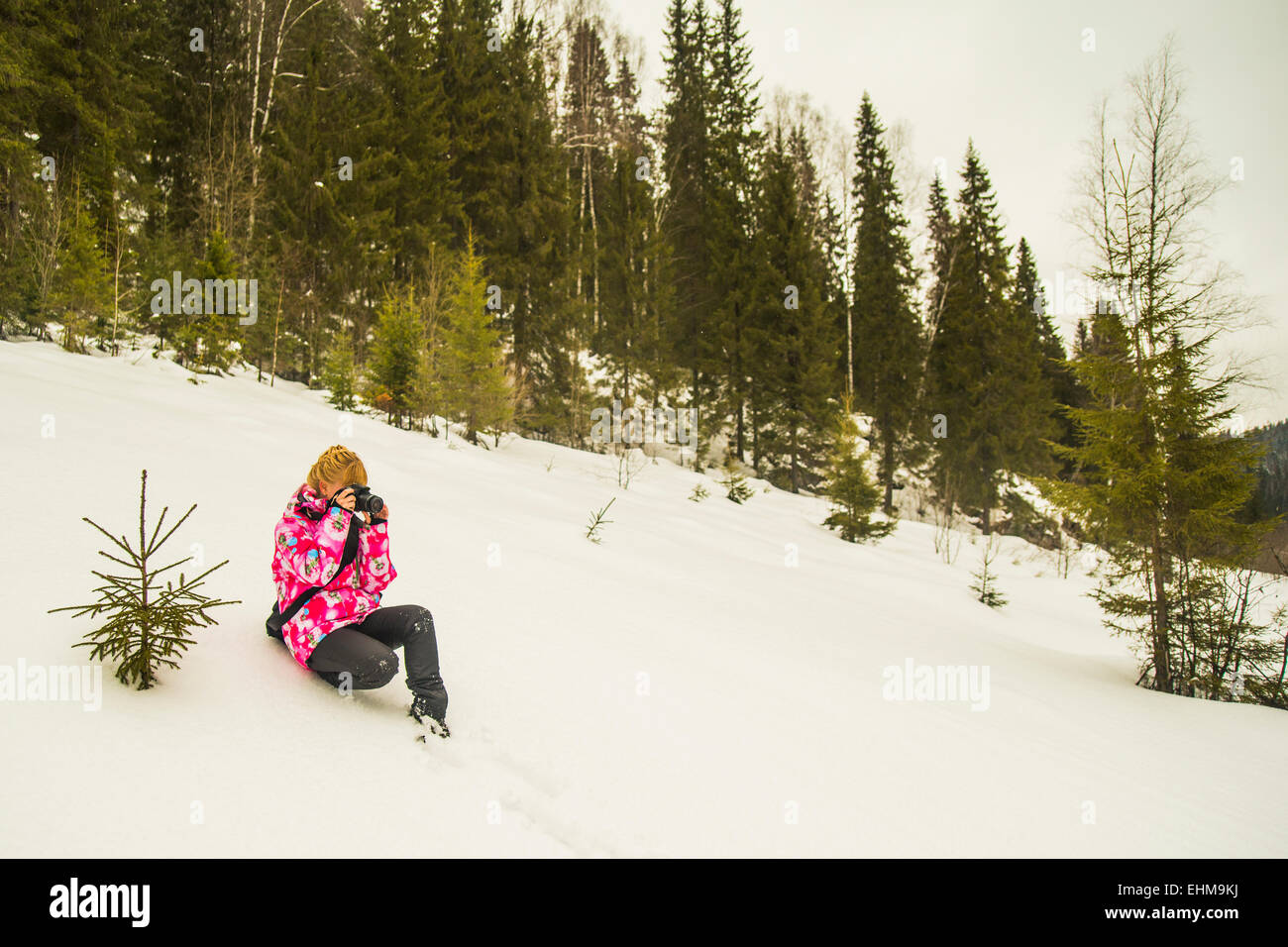 Kaukasische Wanderer sitzen auf verschneiten Hügel Stockfoto