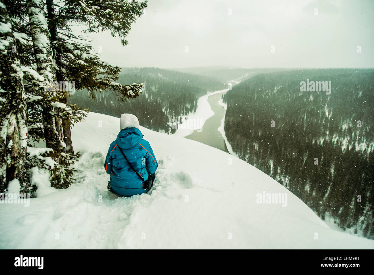 Kaukasische Wanderer sitzen auf verschneiten Hügel Stockfoto