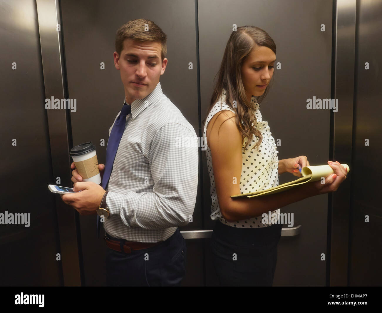 Business-Leute ignorieren einander im Aufzug Stockfoto