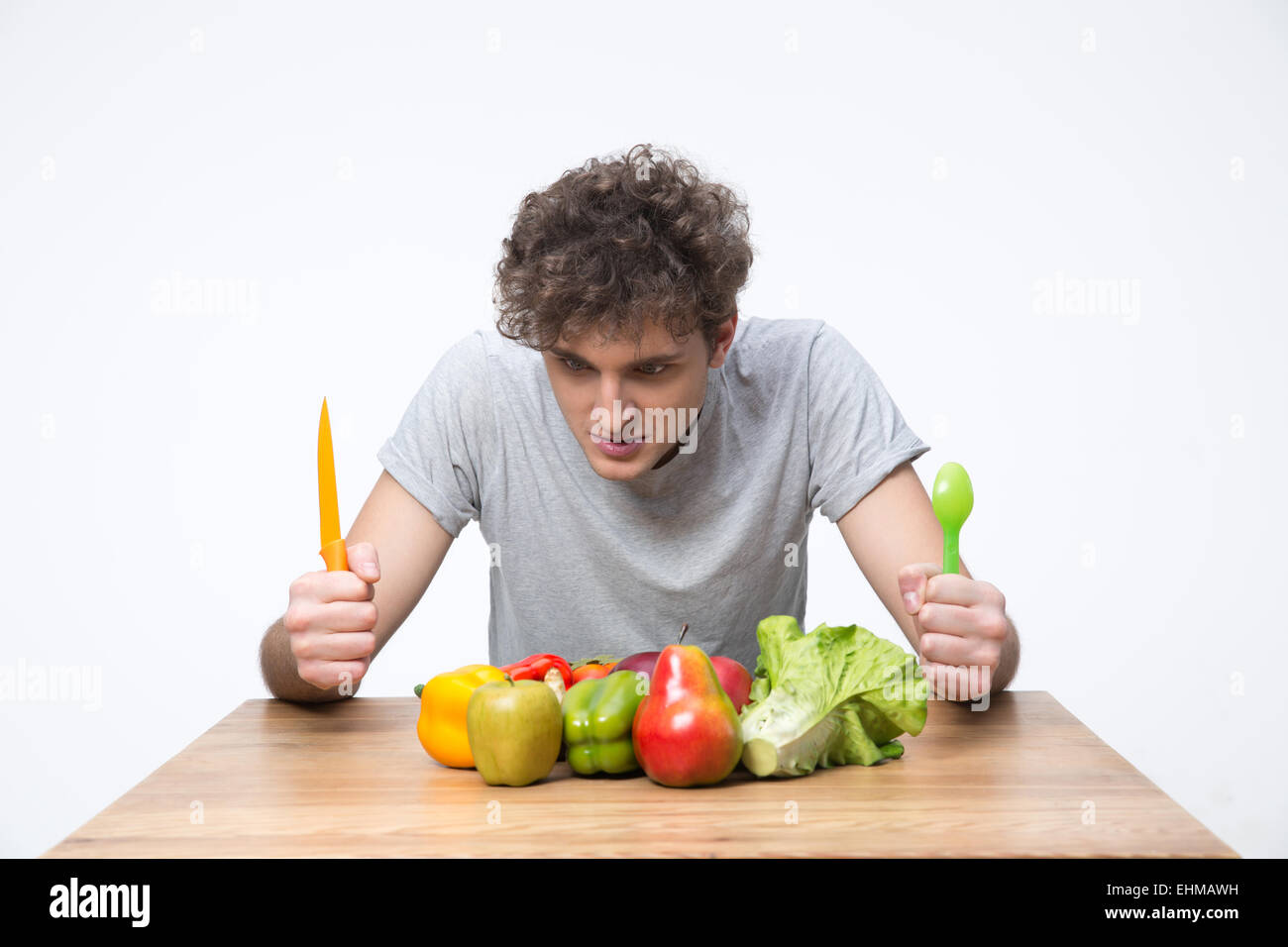 Hungrigen Mann sitzt am Tisch mit Gemüse Stockfoto