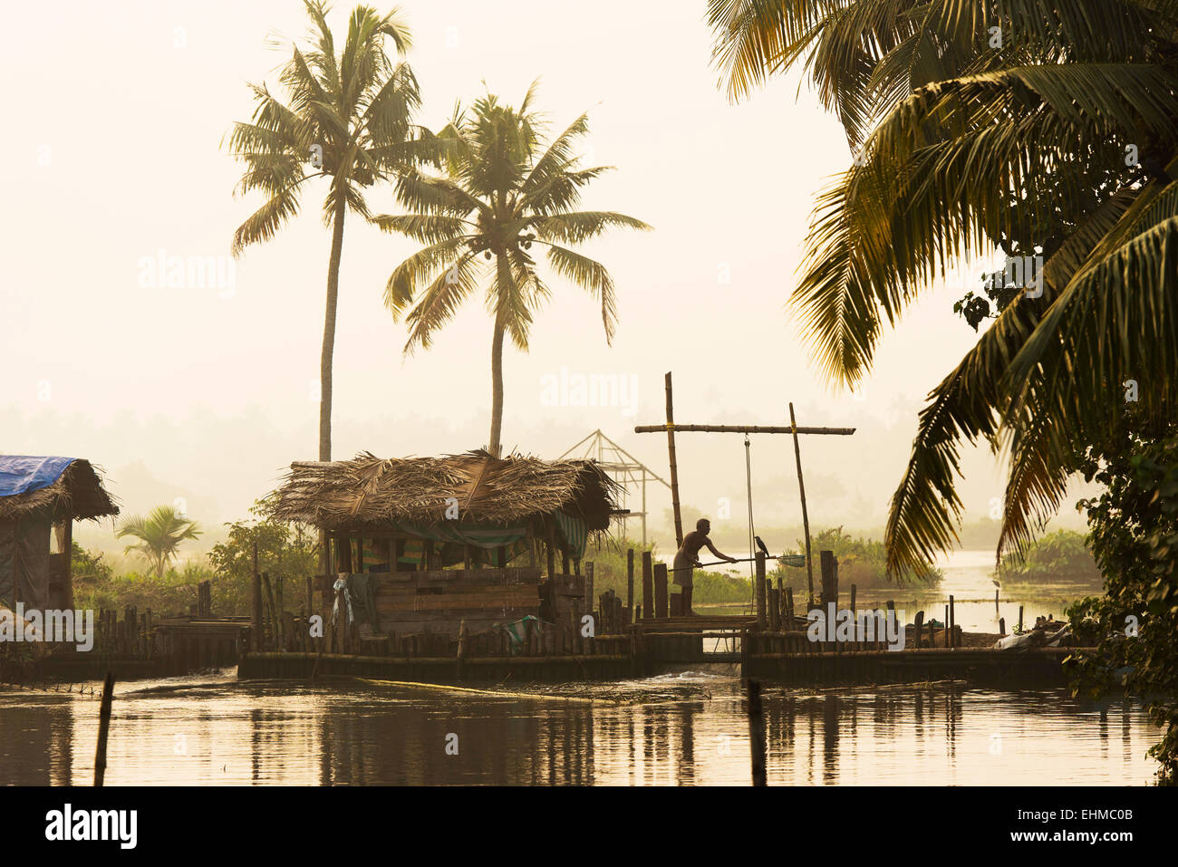 Mann auf hölzerne Schleuse zur Regulierung der Wasserstand der Pokkali Reisfelder während Ebbe und Flut, Backwaters, Ernakulam Bezirk Stockfoto