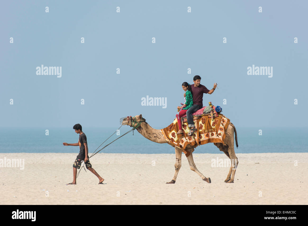 Indische Touristen ein Kamel reiten am Strand, Alappuzha, Kerala, Indien Stockfoto