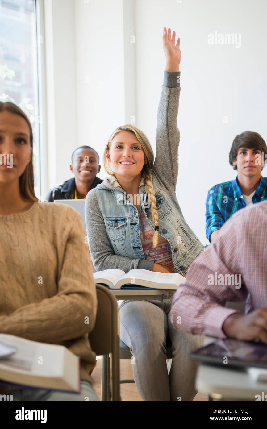 Teenager-Studentin Erhöhung Hand im Klassenzimmer Stockfoto