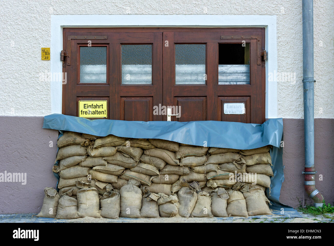 Hochwasserschutz Kontrollmaßnahmen, Sandsäcke und einen Schutzwall aus Stahl Lamellen vor einem Garagentor, Altstadt, Passau Stockfoto