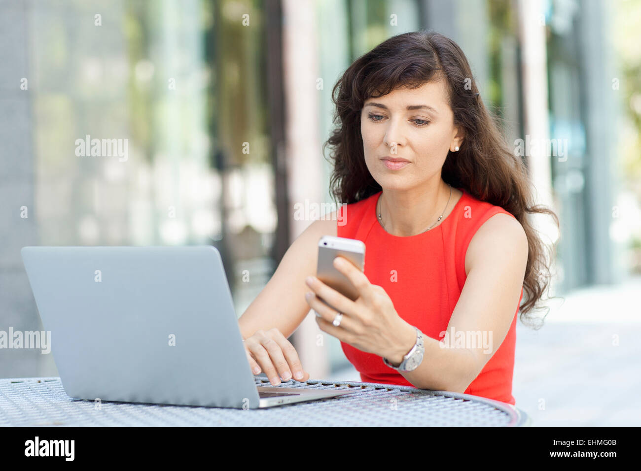 Kaukasische Geschäftsfrau mit Laptop und Handy im freien Stockfoto