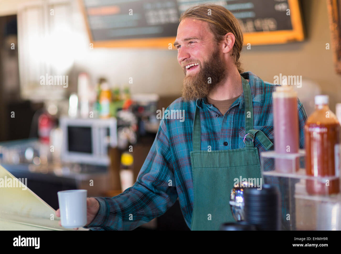 Kaukasische Server halten Tasse Kaffee im café Stockfoto