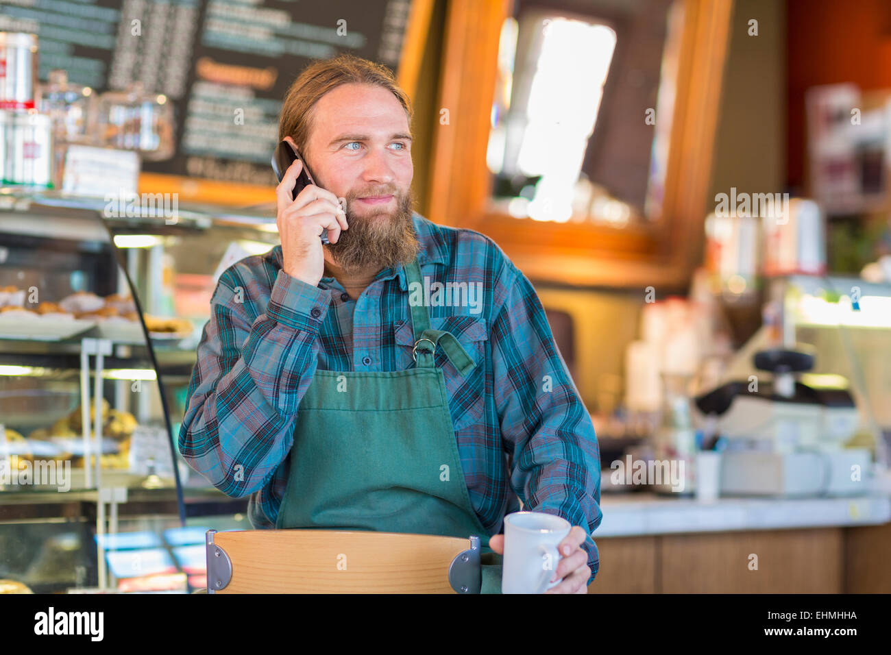 Kaukasische Server Gespräch am Telefon im café Stockfoto