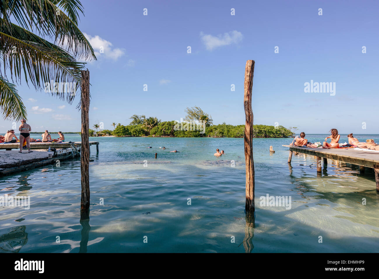 Sonnenanbeter und Schwimmer an der Split auf Caye Caulker genießen die Sonne & Wasser Stockfoto