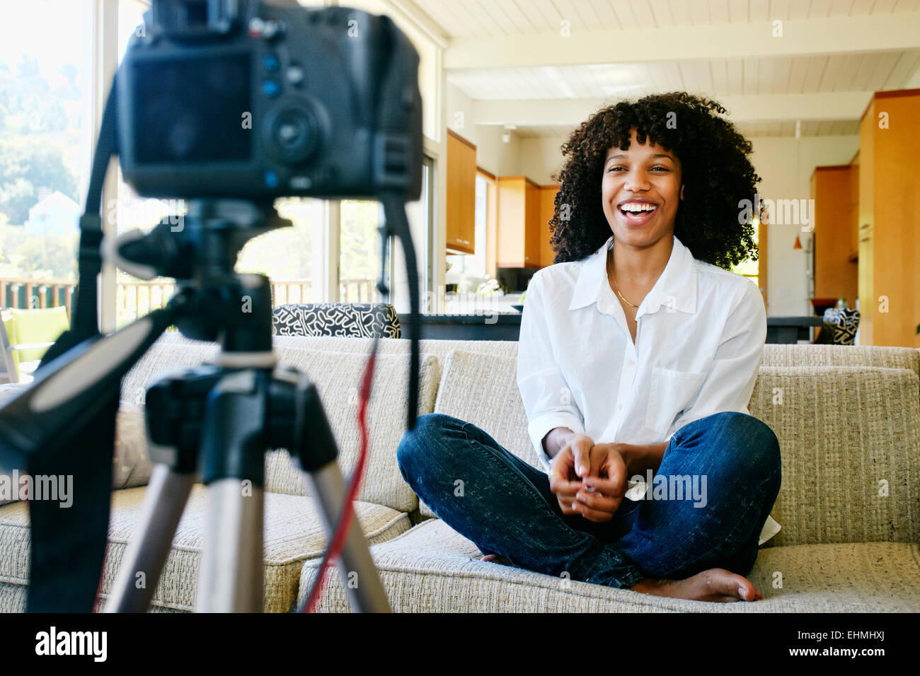 Gemischte Rassen Frau Videoaufnahme von sich selbst im Wohnzimmer Stockfoto