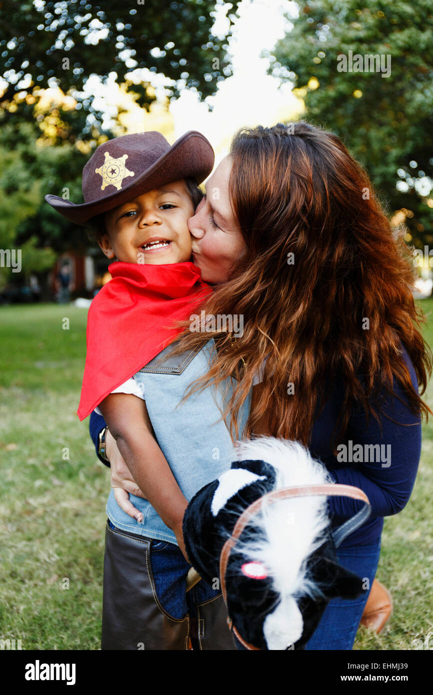 Mutter Sohn küssen für Halloween als Cowboy verkleidet. Stockfoto