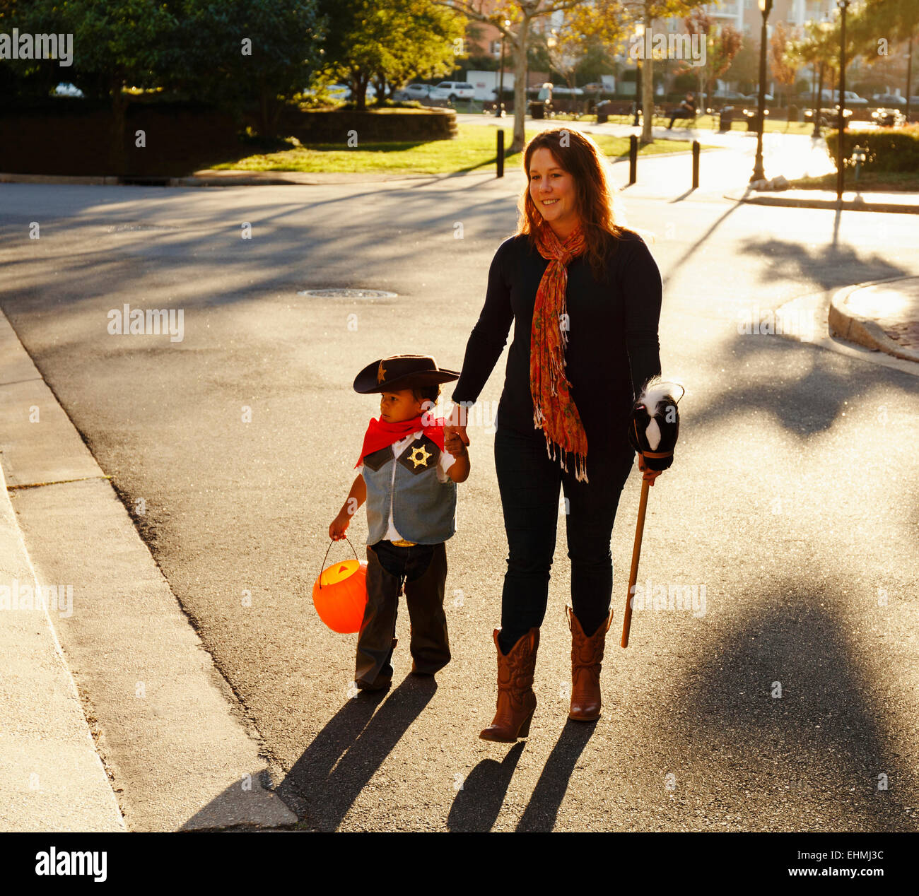Mutter und Sohn verkleidet als Cowboy Kreuzung Straße Stockfoto