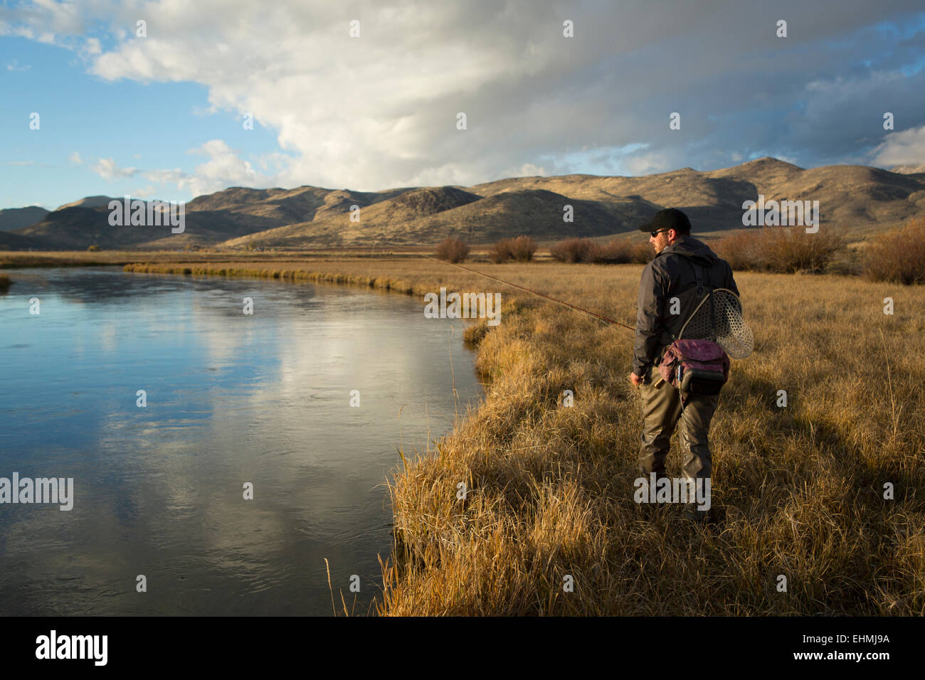 Mann mit Fischen beliefert nahe Fluss Stockfoto
