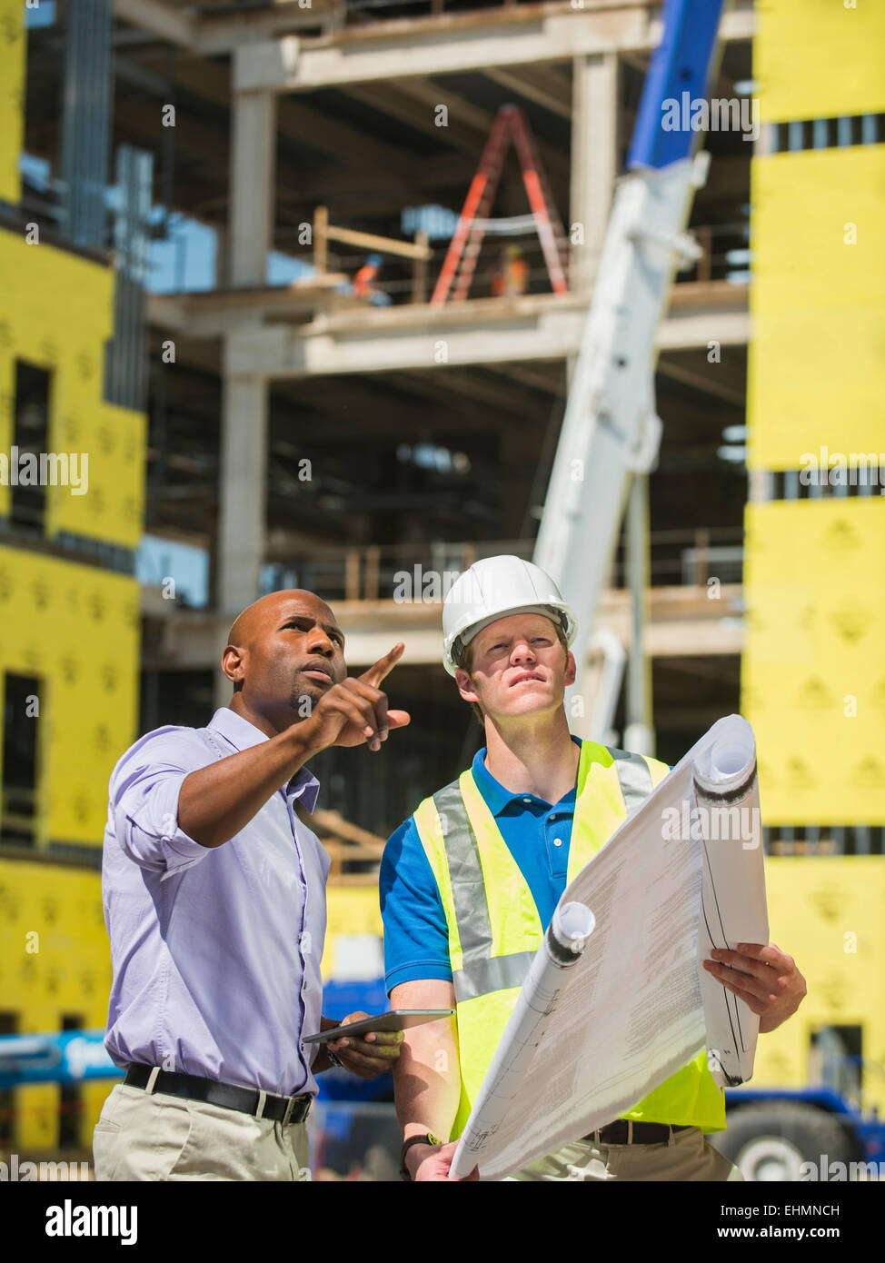 Geschäftsmann und Bau Arbeiter lesen Blaupausen auf Baustelle Stockfoto
