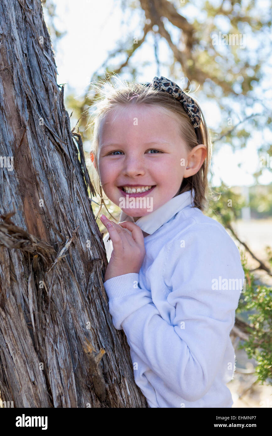 Gemischte Rassen Mädchen lächelnd in der Nähe von Baum im freien Stockfoto