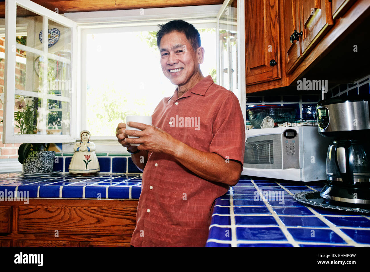 Philippinischen Mann trinken Kaffee in der Küche Stockfoto