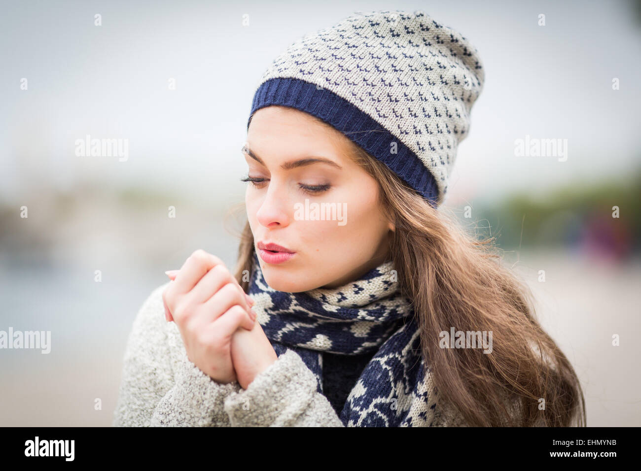 Frau bläst auf seine Hände. Stockfoto