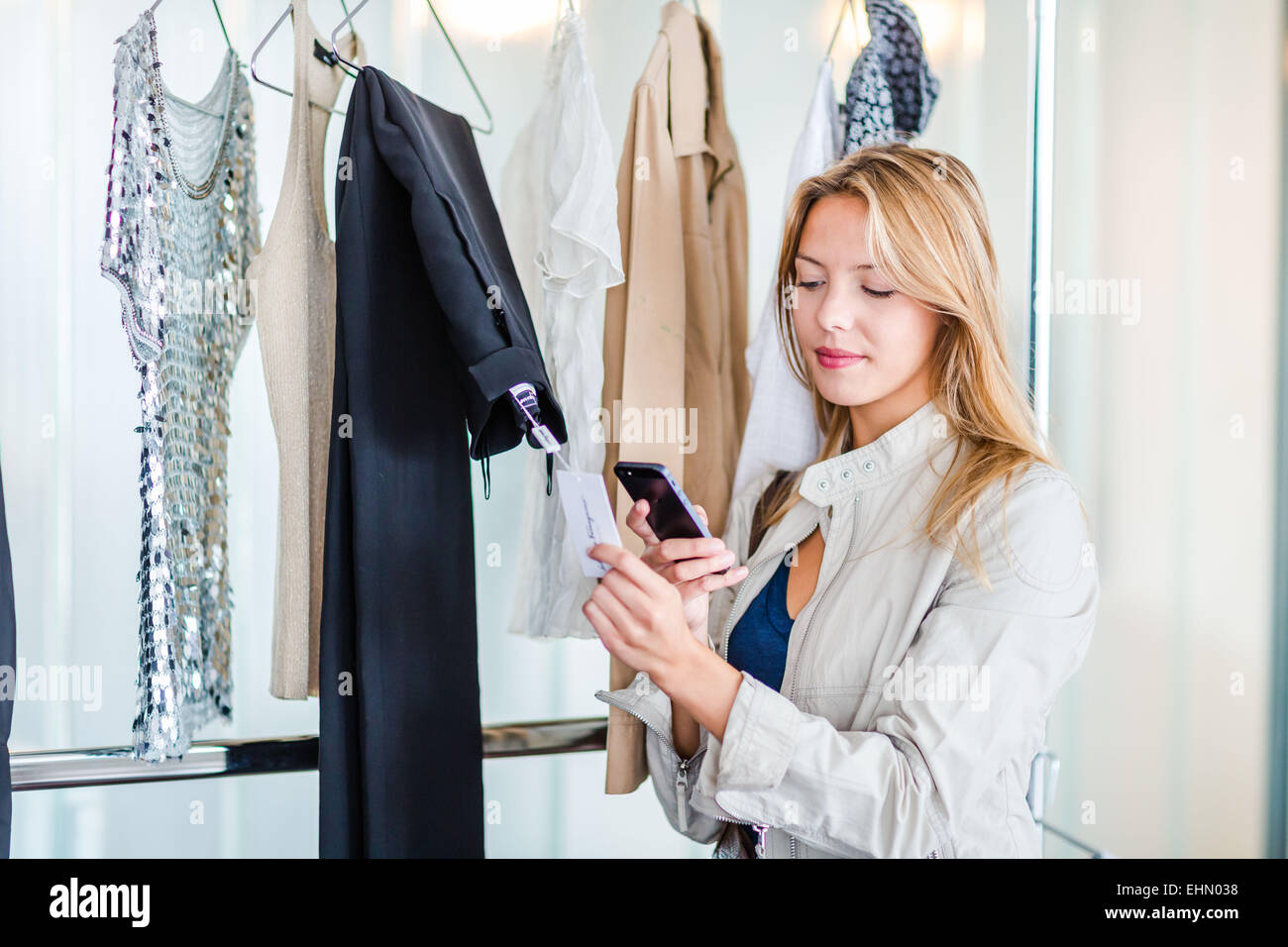 Frau mit einem Smartphone im Stoff-Shop. Stockfoto
