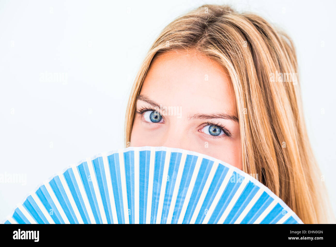 Frau, die ihr Gesicht mit einem Ventilator zu kühlen. Stockfoto