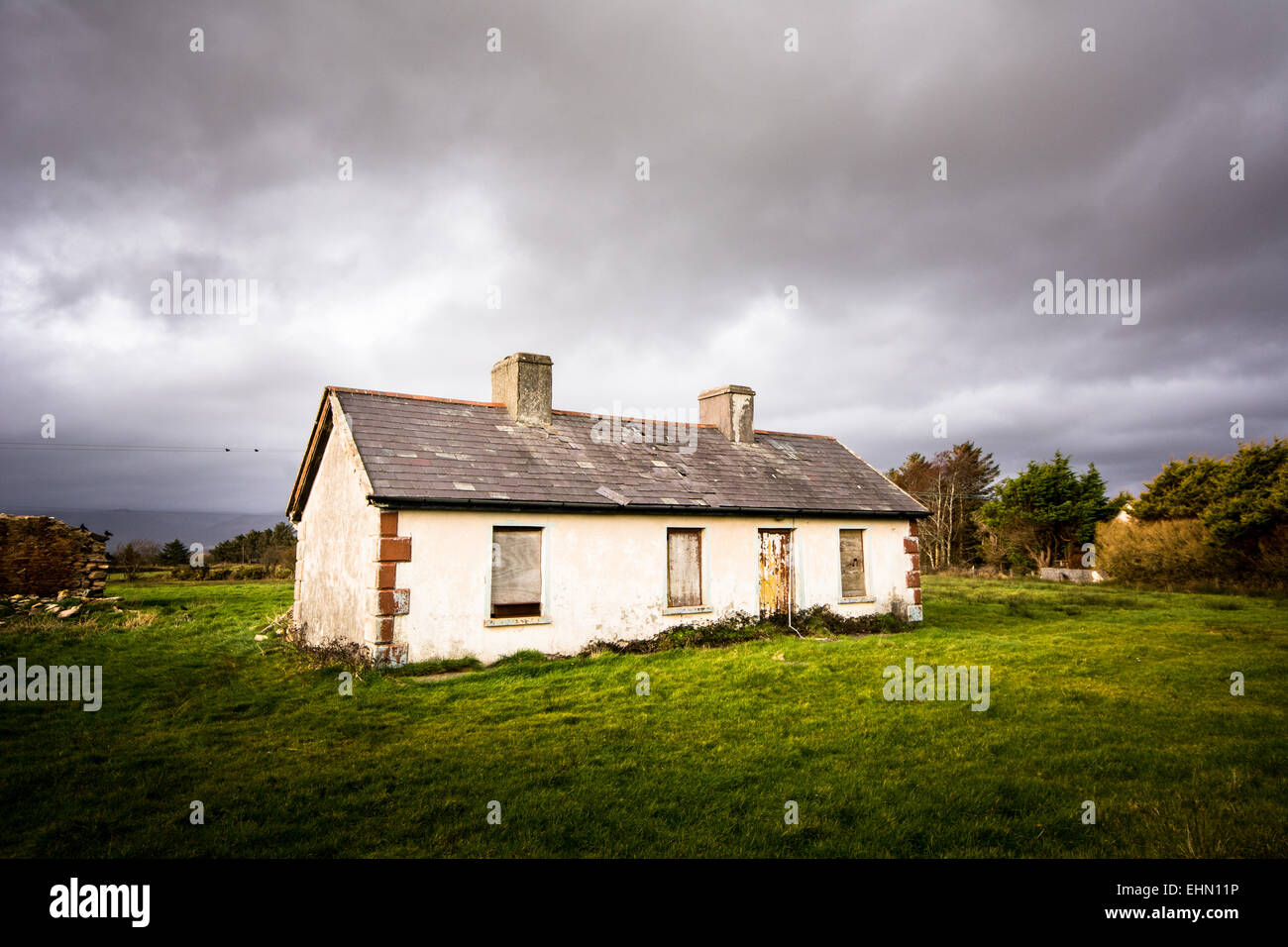 Verlassenen ländlichen Hausruine mit Fenstern mit Brettern vernagelt im Westen Irlands Stockfoto