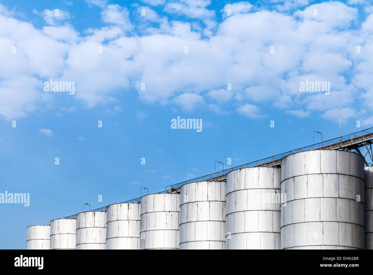 Abstrakte Industriearchitektur Fragment auf blauen Himmelshintergrund, glänzende Metall-Tanks für die Lagerung von Schüttgütern Stockfoto