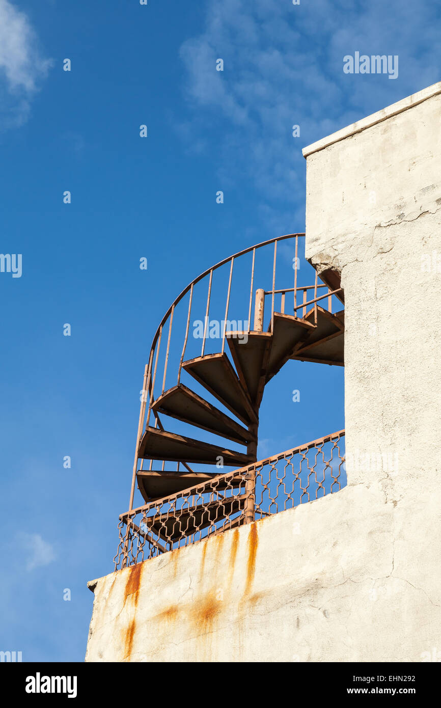 Abstrakt Architektur Fragment, alte Outdoor-Metall-Spirale-Leiter an der Wand Stockfoto