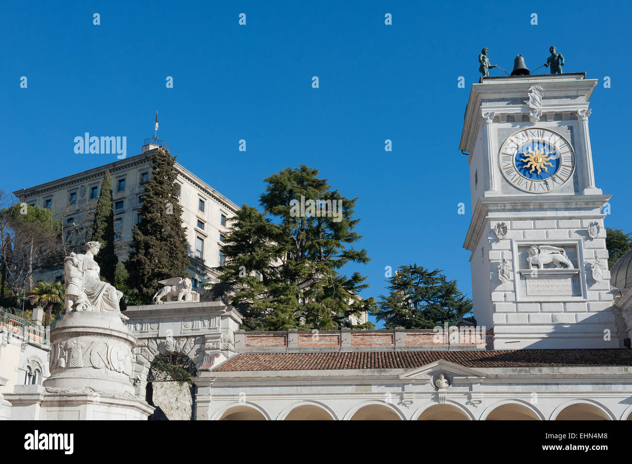 Die Statue des Friedens mit dem Glockenturm der Kirche. In Freiheitsplatz, Udine, Italien Stockfoto