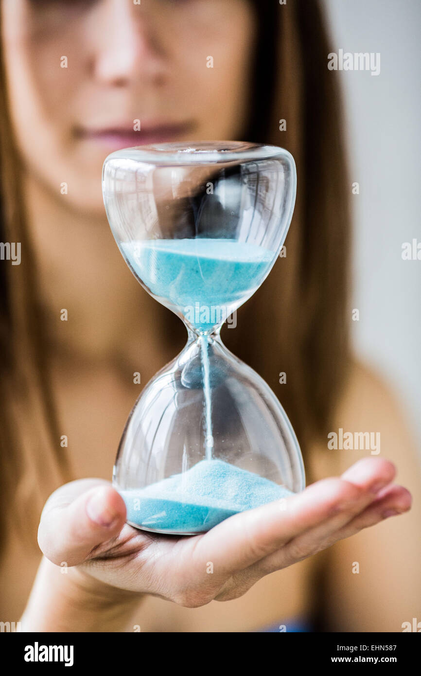 Frau hält eine Sanduhr. Stockfoto