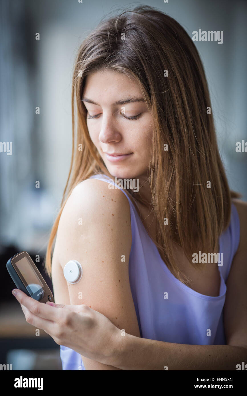 Eine diabetische Person prüft ihr Blutzuckerspiegel (selbst Glycemia) mit FreeStyle Libre®. Stockfoto