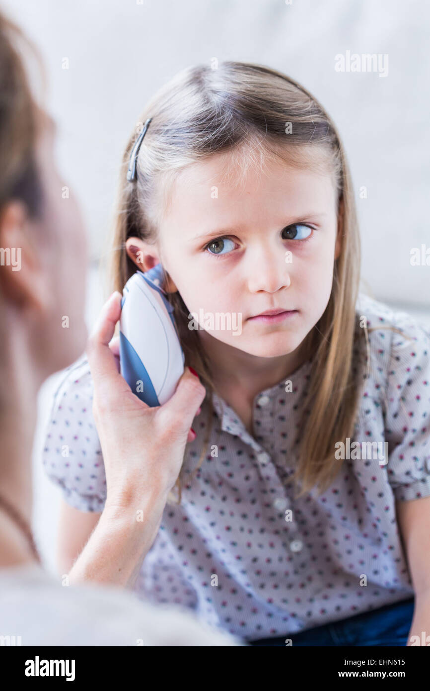 Überprüfen die Temperatur eines 4 Jahre alten Mädchens mit Ohr-Thermometer. Stockfoto