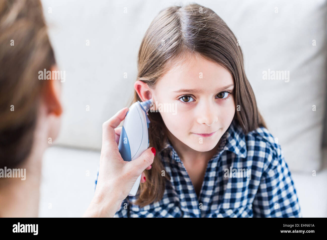 Überprüfen die Temperatur eines 7-jährigen Mädchens mit Ohr-Thermometer. Stockfoto