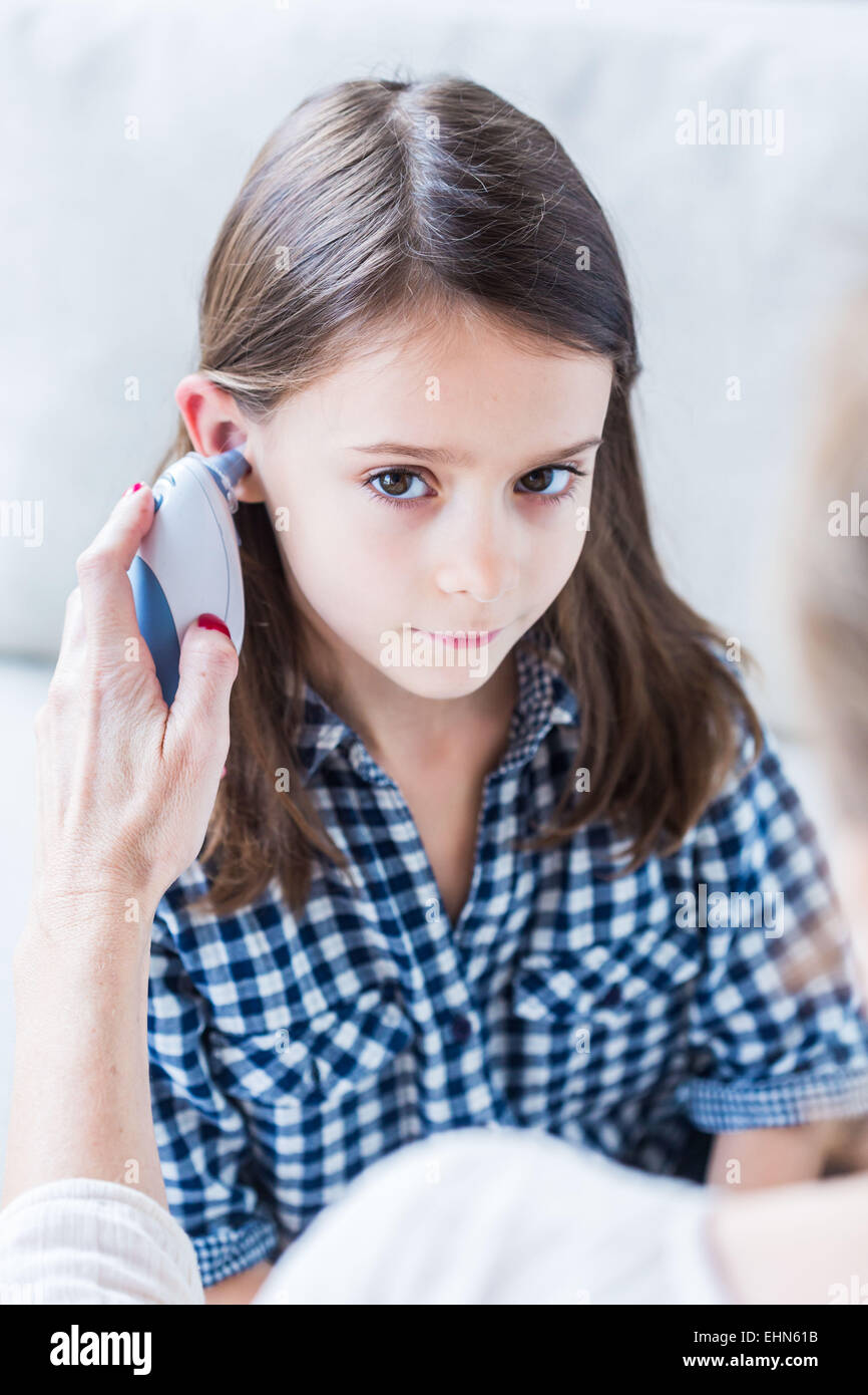 Überprüfen die Temperatur eines 7-jährigen Mädchens mit Ohr-Thermometer. Stockfoto
