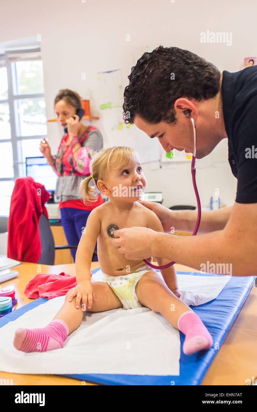 Arzt untersucht ein 2 Jahre alten Mädchen mit einem Stethoskop, Mutter und Kinder-und Jugendhilfe, Charente, Frankreich. Stockfoto