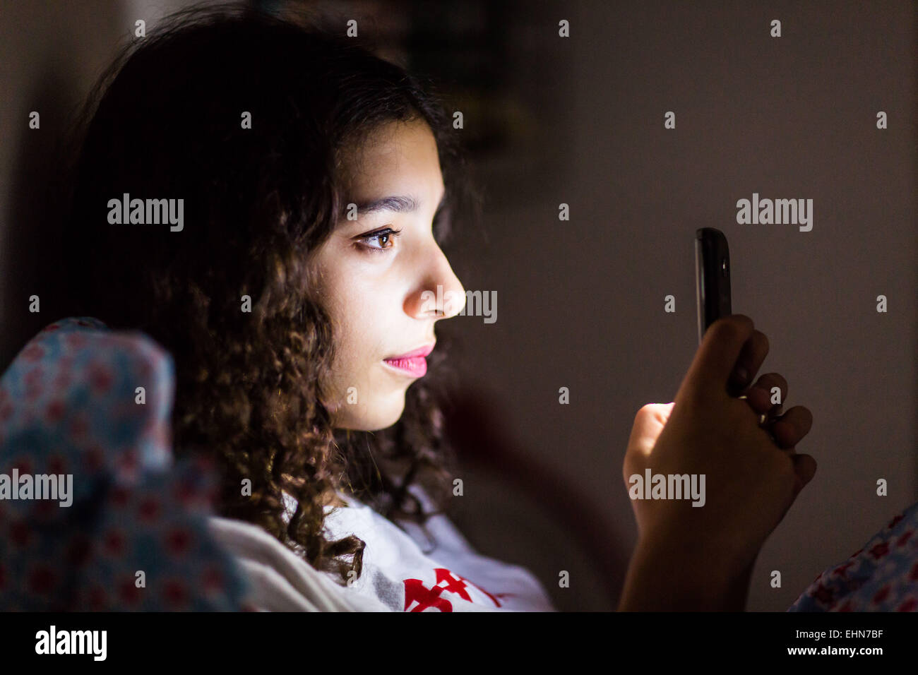 Teenager-Mädchen mit einem Smartphone in der Nacht. Stockfoto