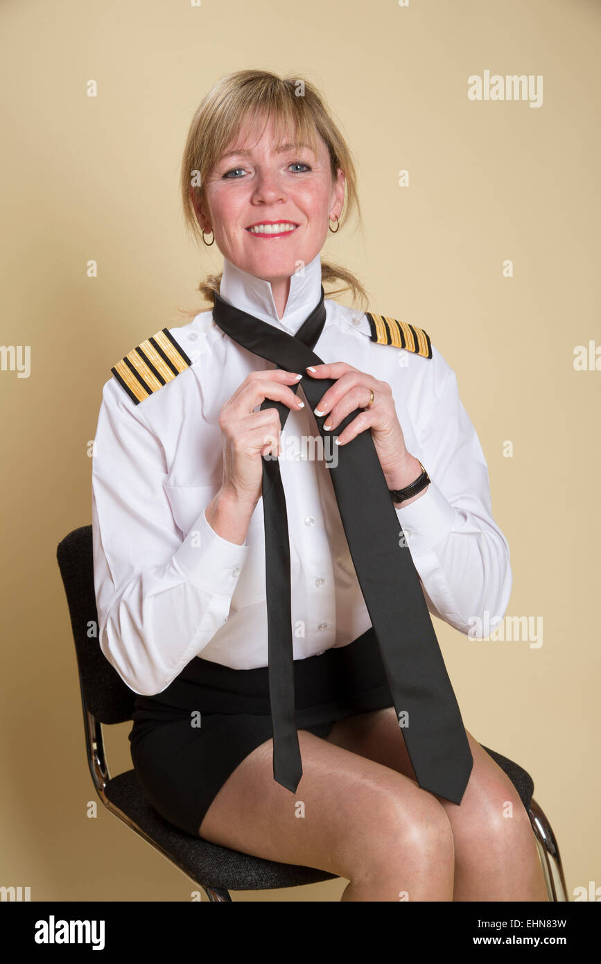 Attraktive weibliche Flugkapitän eine einheitliche schwarze Krawatte binden Stockfoto