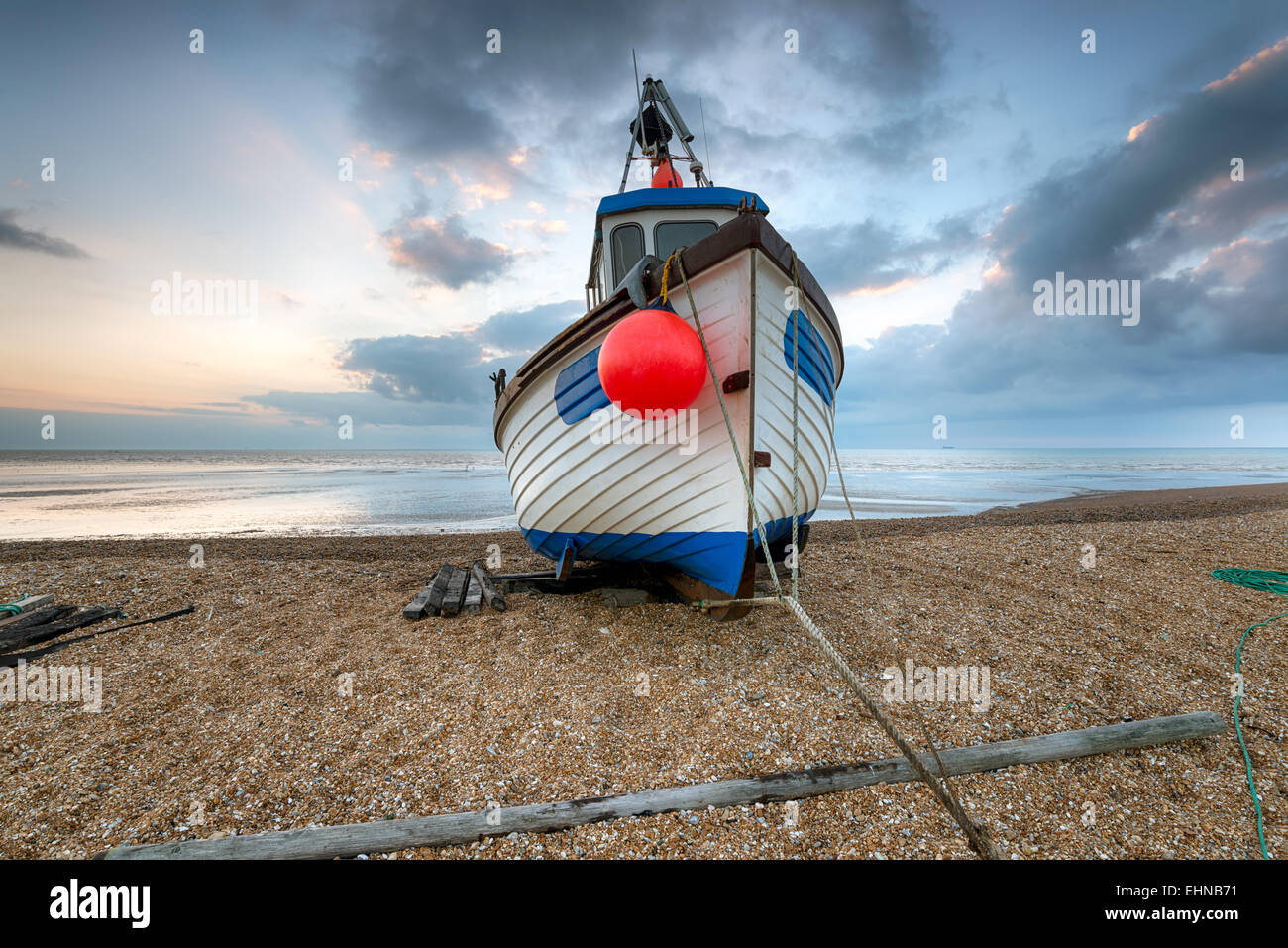 Angelboot/Fischerboot im Morgengrauen auf einem Kiesstrand Stockfoto