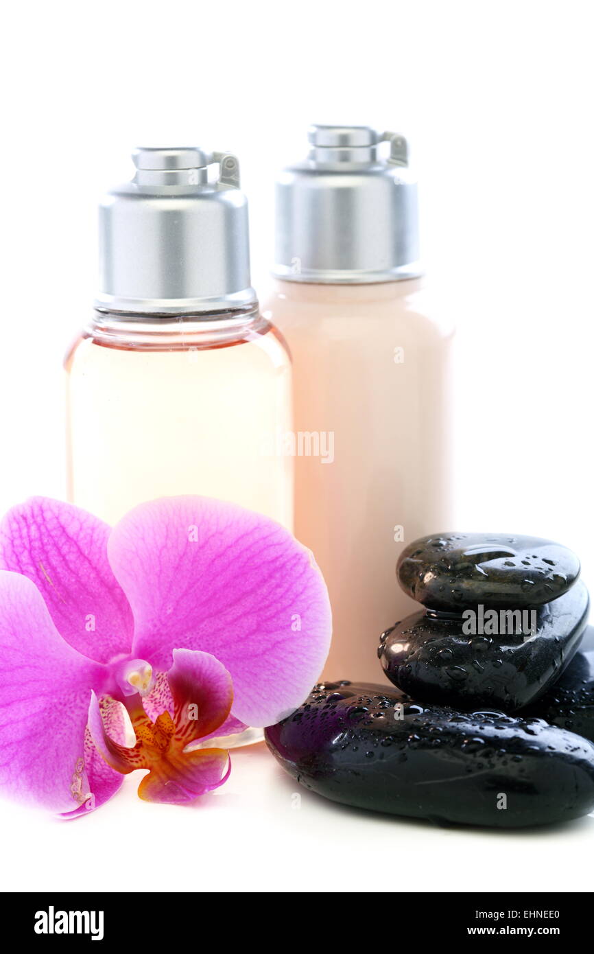 Flaschen mit Kosmetik, Steinen und Orchidee Stockfoto