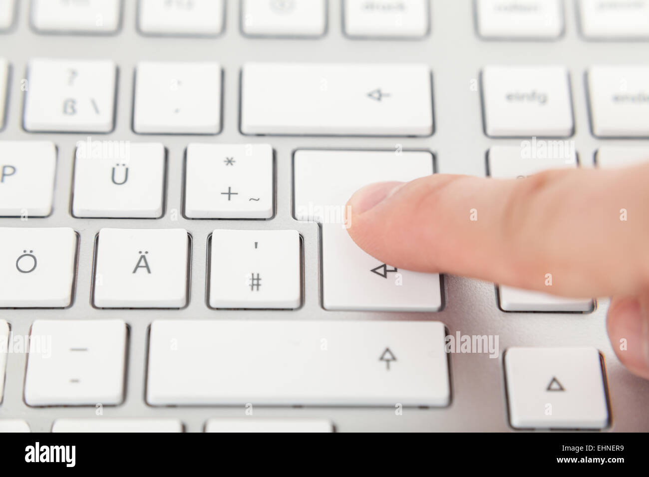 Finger auf enter-Taste auf der Tastatur Stockfoto