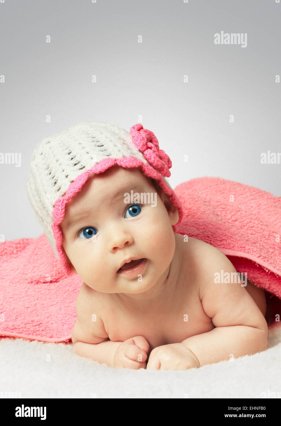 Lustige kleine Neugeborenes trägt einen Hut mit Handtuch Stockfoto