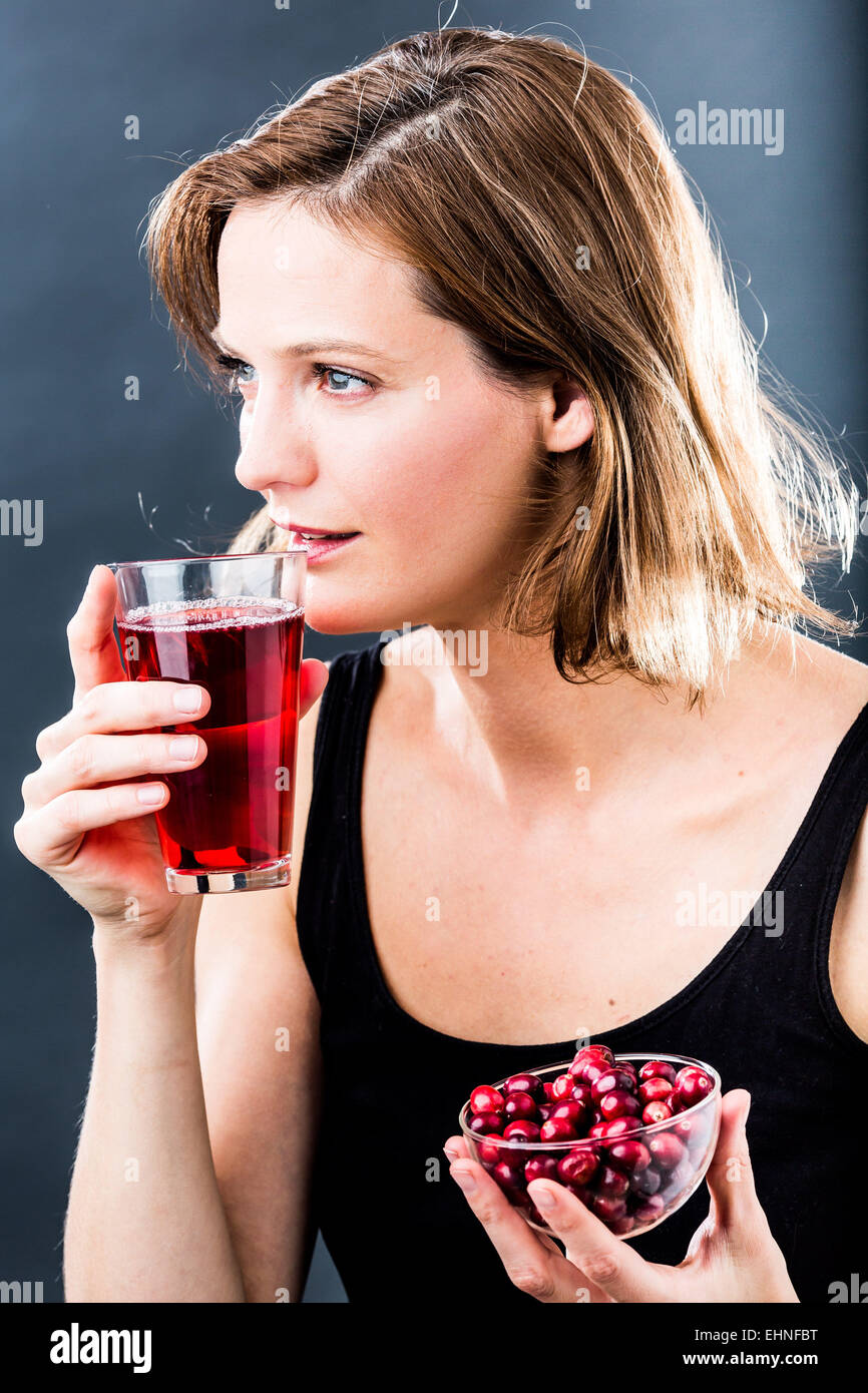 Frau trinkt ein Glas Cranberry-Saft. Stockfoto
