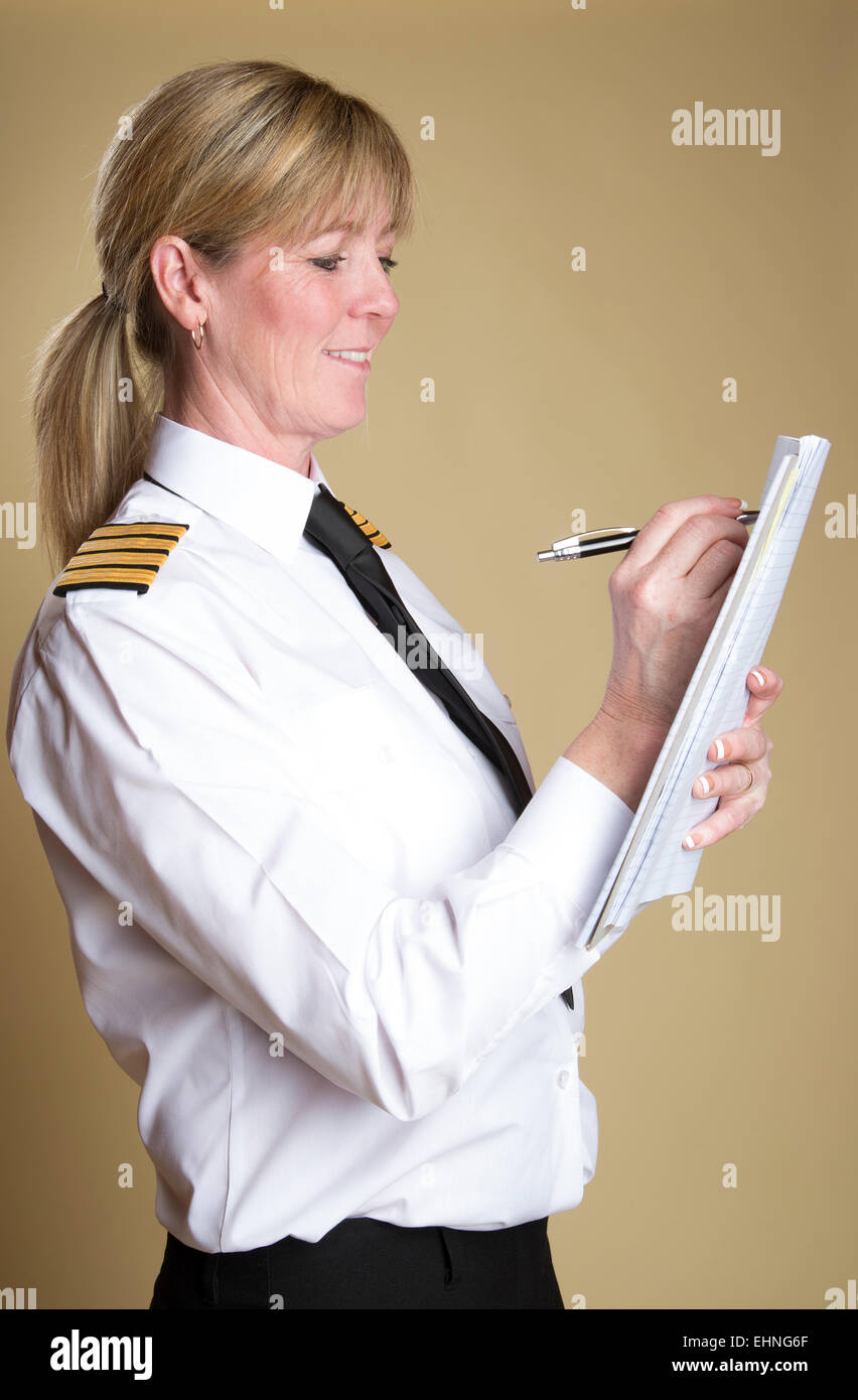 Weibliche Flugkapitän in Uniform und hält einen Stift Stockfoto