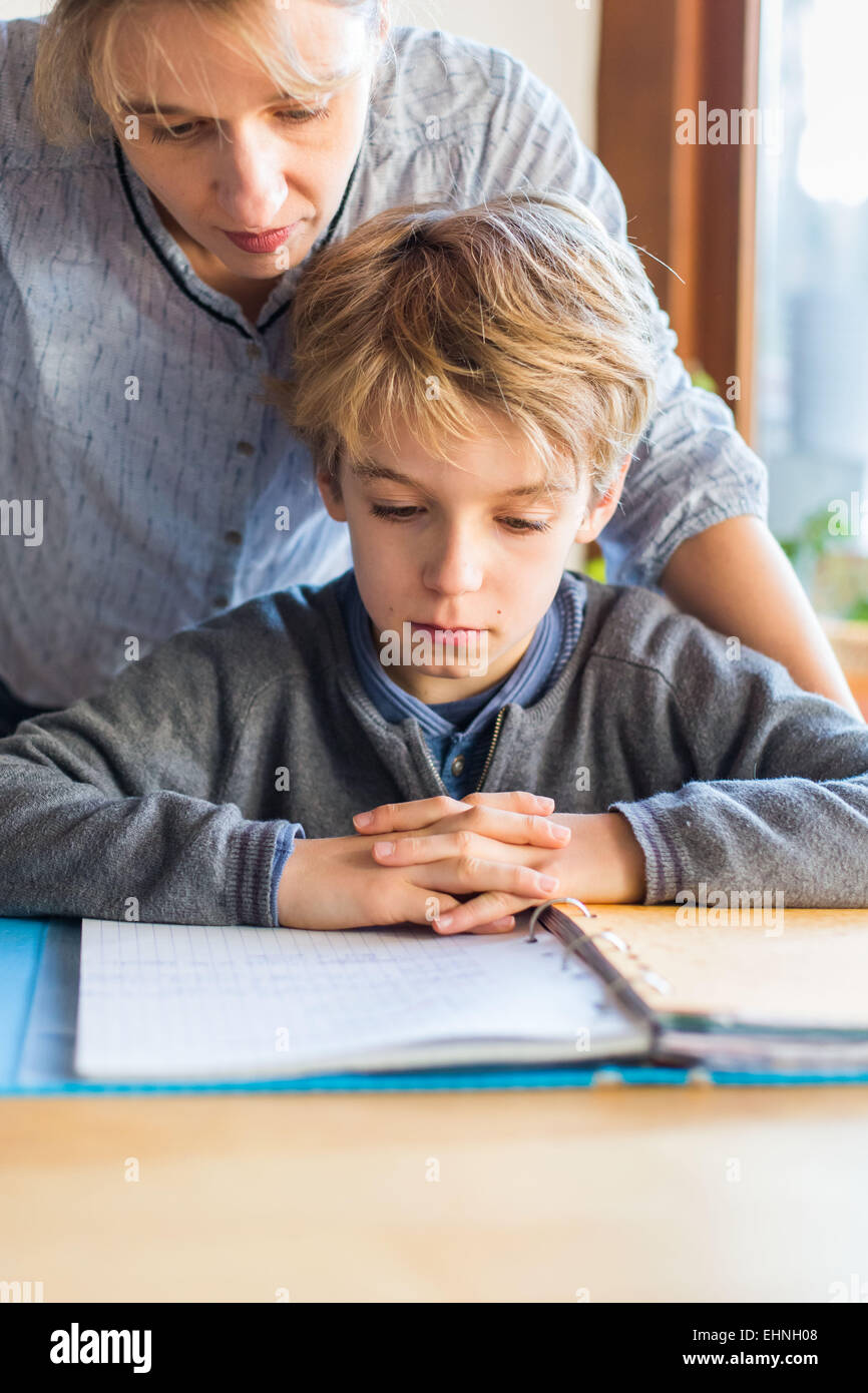 8 Jahre alter Junge Hausaufgaben mit seiner Mutter. Stockfoto