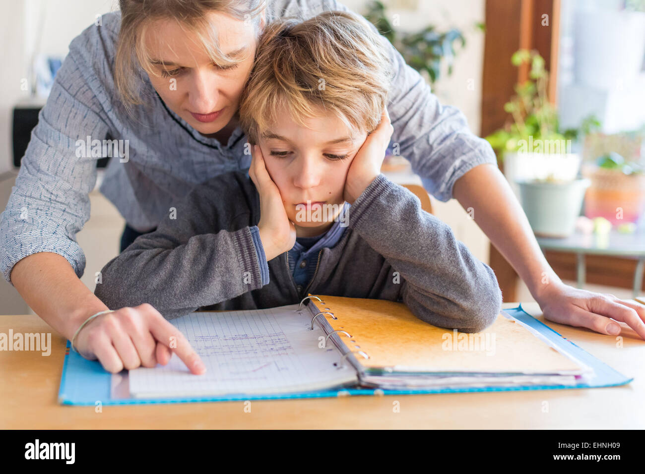 8 Jahre alter Junge Hausaufgaben mit seiner Mutter. Stockfoto
