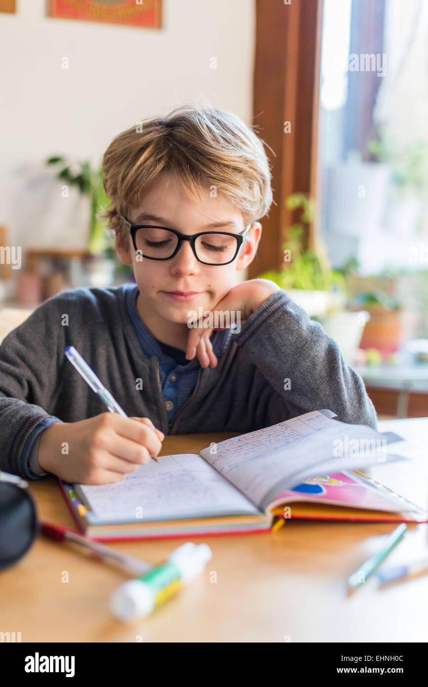 8 Jahre alter Junge in sein Notizbuch schreiben. Stockfoto
