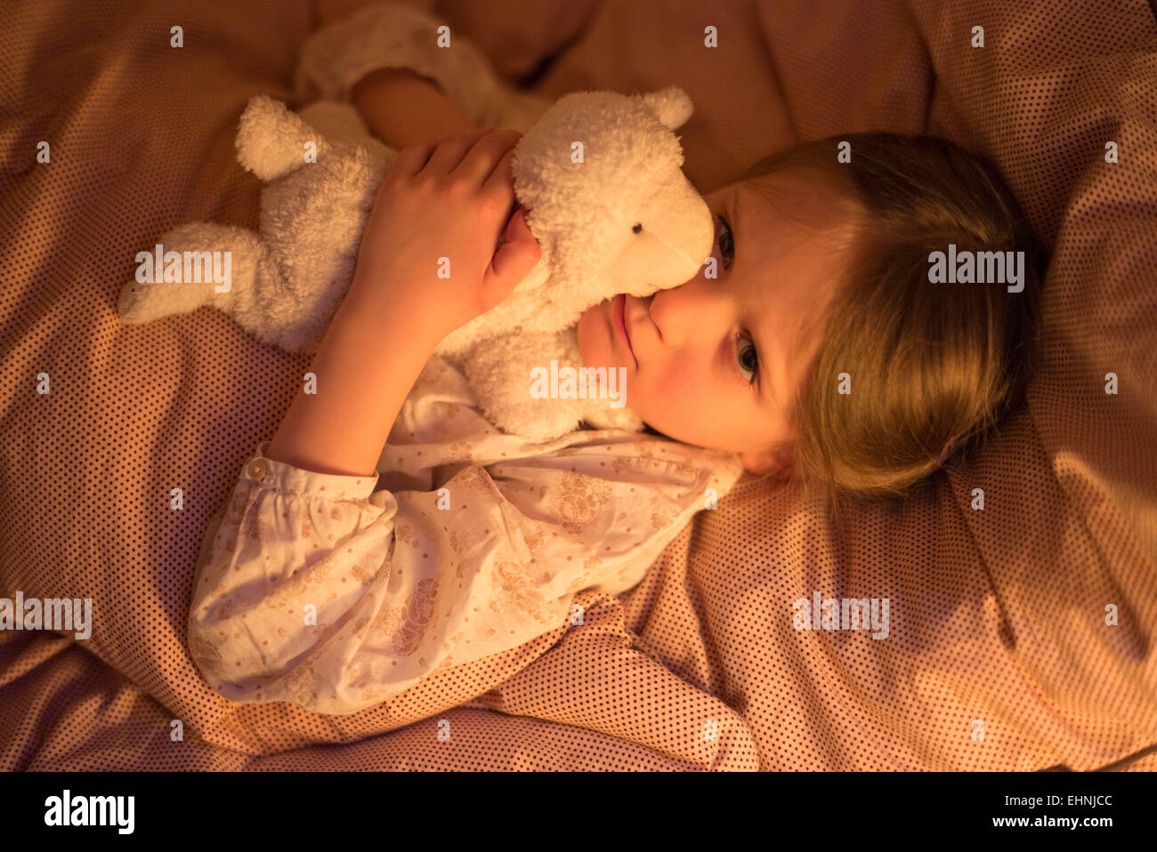 5 Jahre altes Mädchen auf dem Bett liegend. Stockfoto